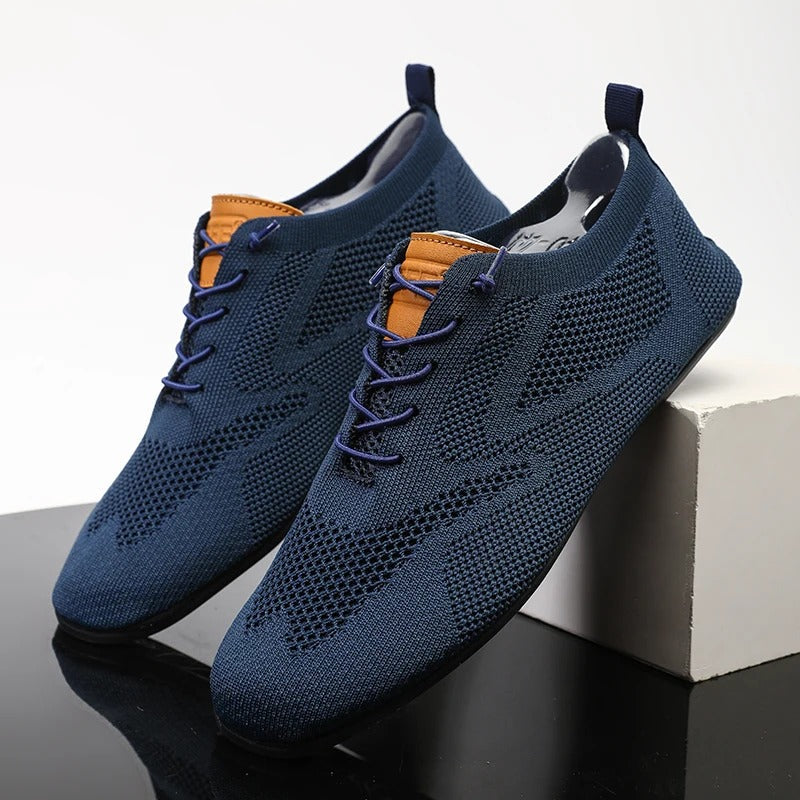 Close-up of men's mesh knit slip-on sneakers, highlighting breathable texture & lightweight design.