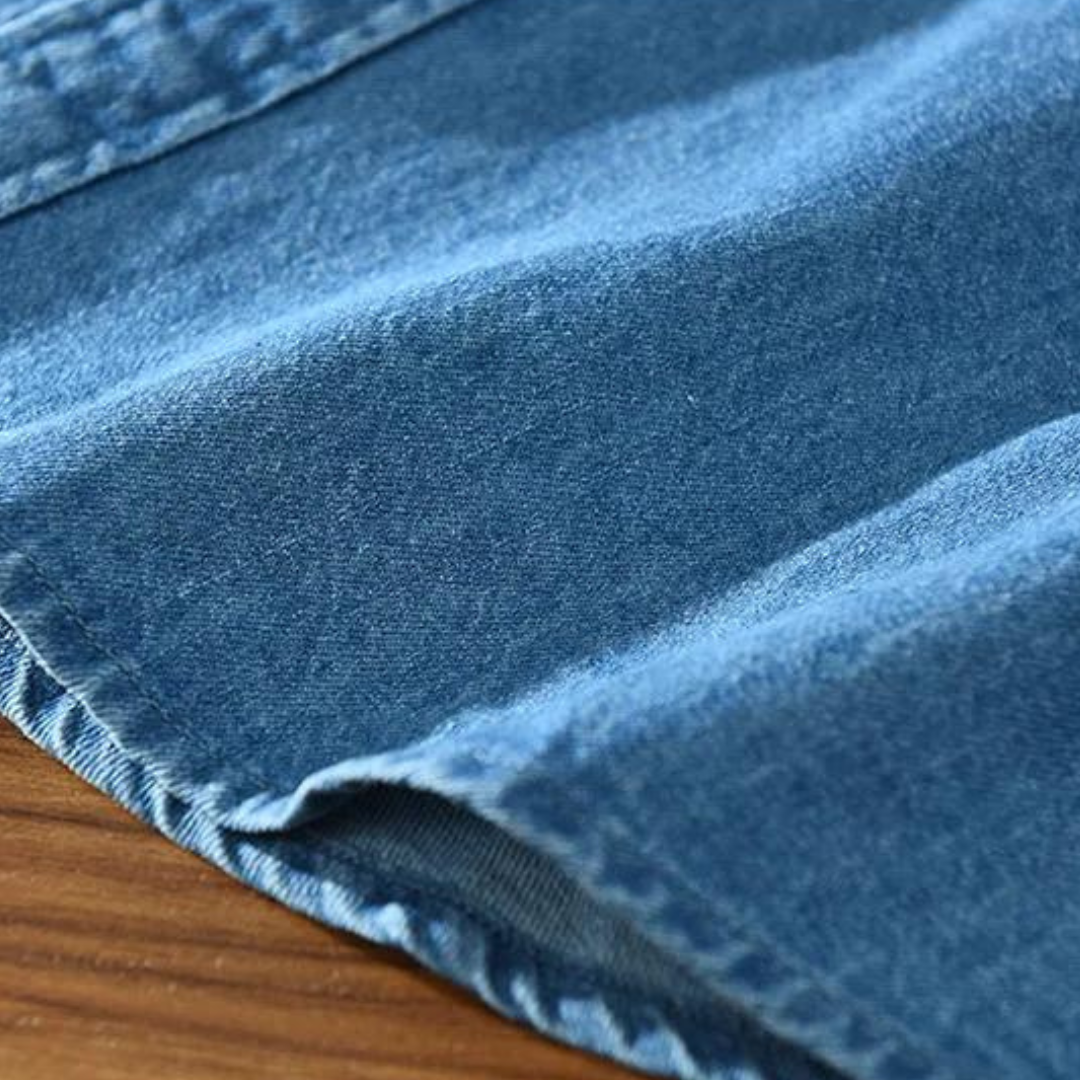 Close-up of men's black denim shirt fabric, highlighting texture & modern fit for casual style.