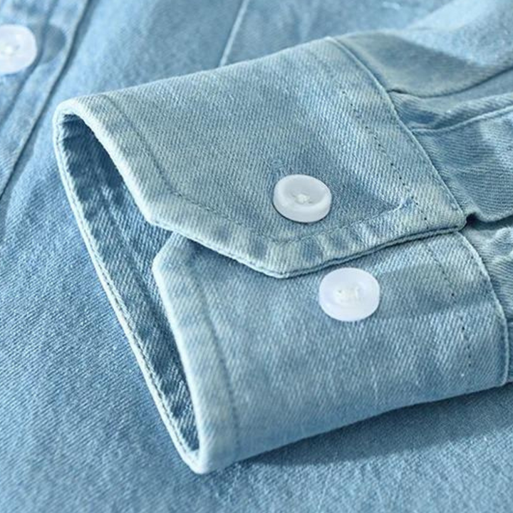 Detail of collar & buttons on a men's modern fit versatile denim shirt, showcasing quality & style.