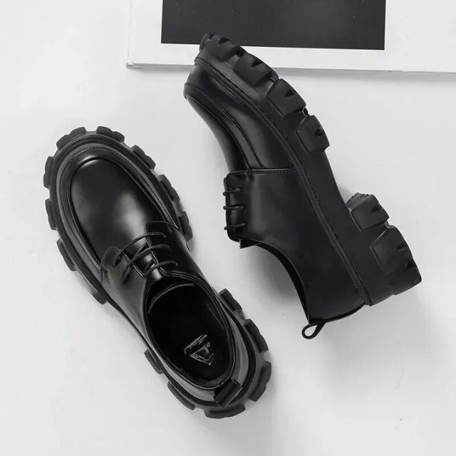 Black low-top men's dress shoes with a contemporary thick sole, suitable for business or casual outfits.
