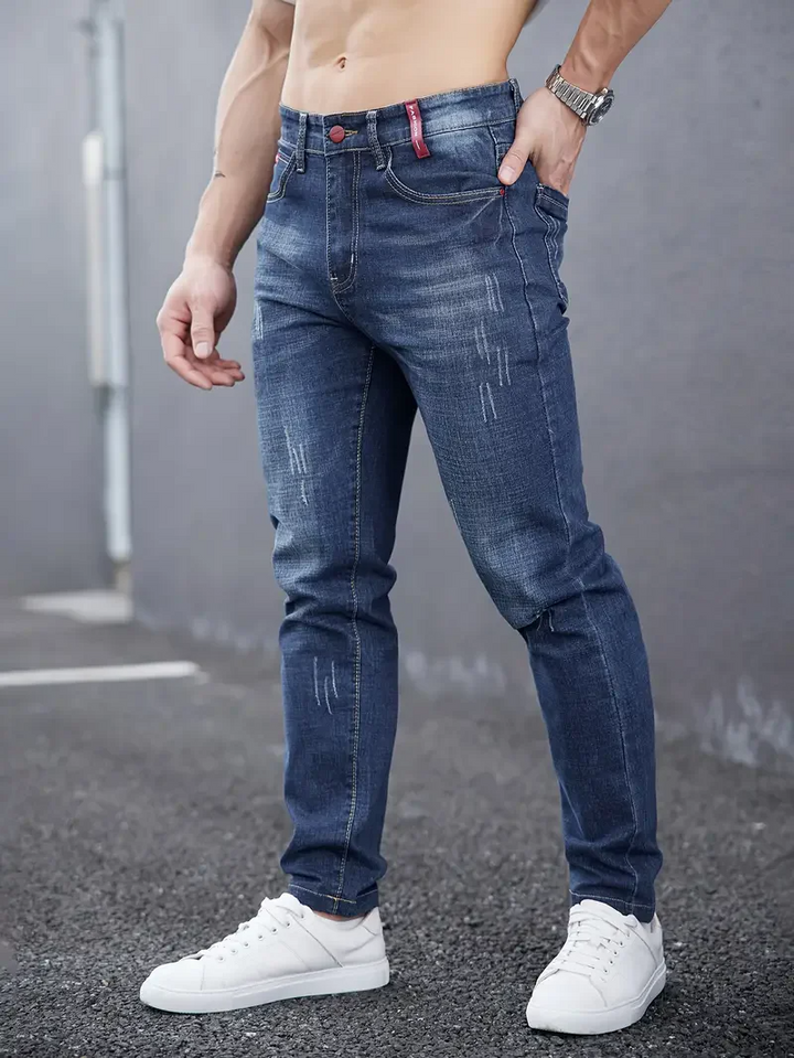 Modern men's slim fit tapered distressed jeans. Stretch denim, perfect for casual urban style & comfort.