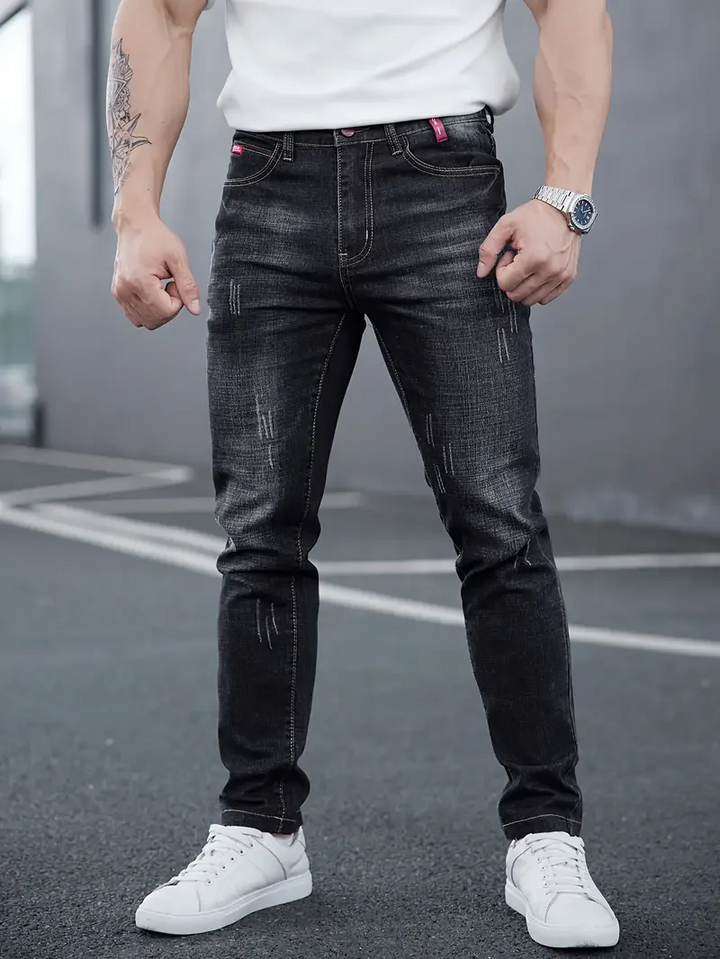 Slim fit men's tapered jeans with modern distressing. Stretch denim for comfortable, stylish casual wear.