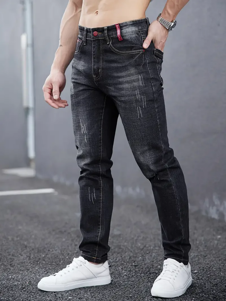 Distressed men's tapered jeans, a slim fit modern denim choice. Ideal for men's fashion & urban style.