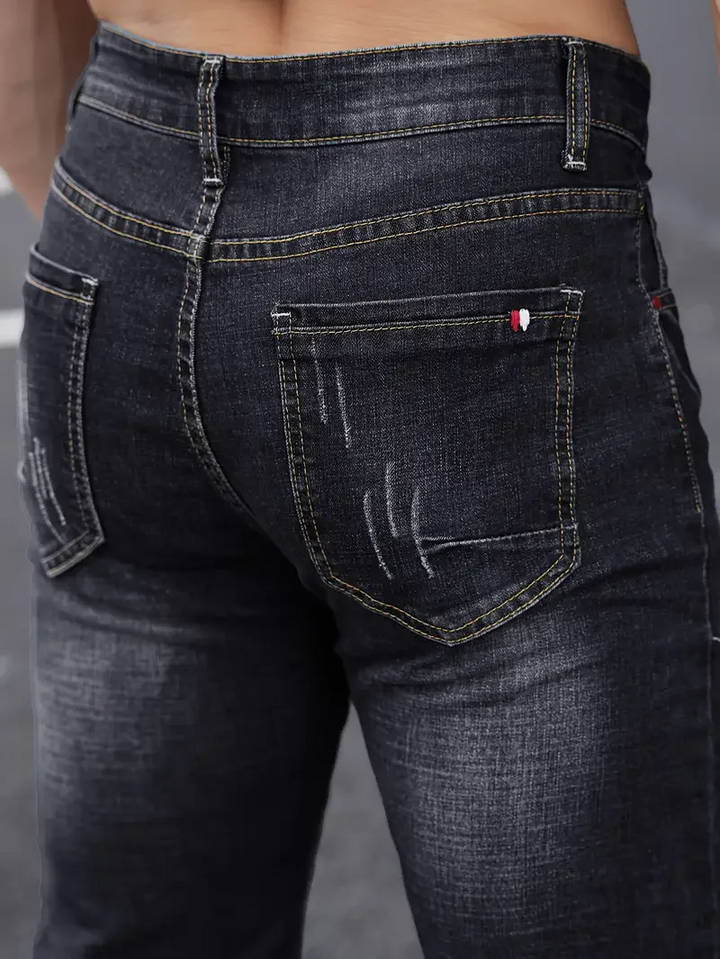 Casual men's slim fit tapered jeans with stylish distressing. Urban fashion denim for a modern look.