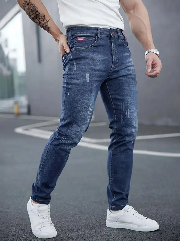 Tapered men's jeans, slim fit distressed denim. Modern stretch jeans for a sleek, comfortable urban style.