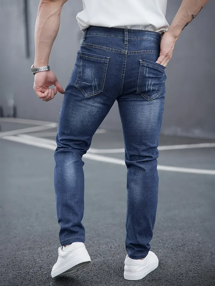 Distressed men's slim fit tapered jeans. Modern denim for casual wear, showcasing urban style & fashion.