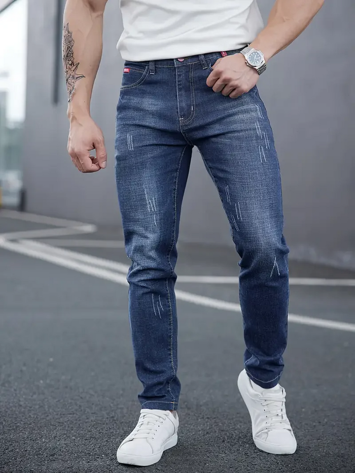 Fashionable men's tapered jeans, slim fit with distressed details. Modern stretch denim for urban casual.