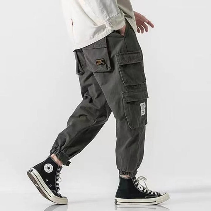Stylish men's black cargo joggers with spacious utility pockets & tapered leg for modern comfort.
