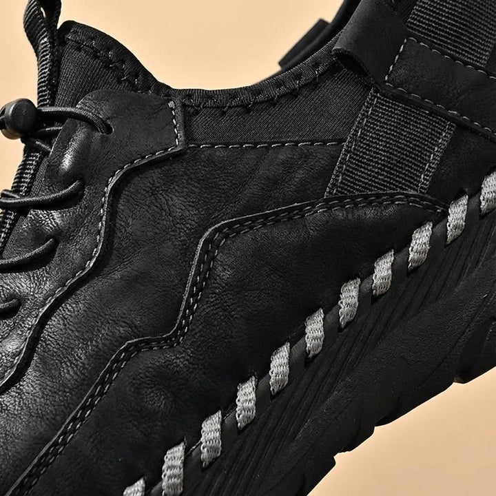 Close-up of men's outdoor walking shoes, showcasing non-slip sole & breathable dark fabric