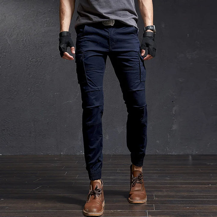 Front view of men's Outland tapered fit cargo pants with large utility pockets & elastic cuffed ankles for adventure.