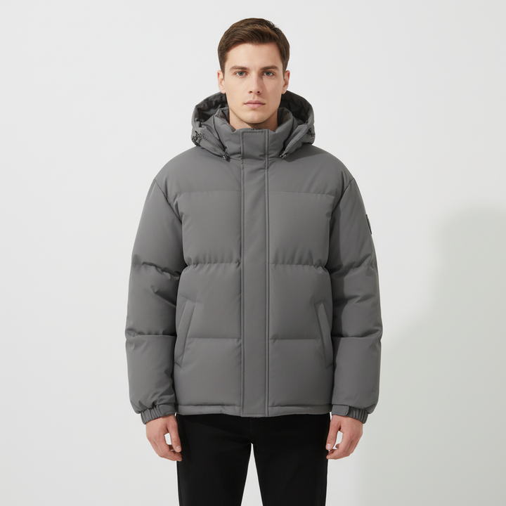 Men's padded outdoor jacket against a snowy backdrop, highlighting its warmth for winter.