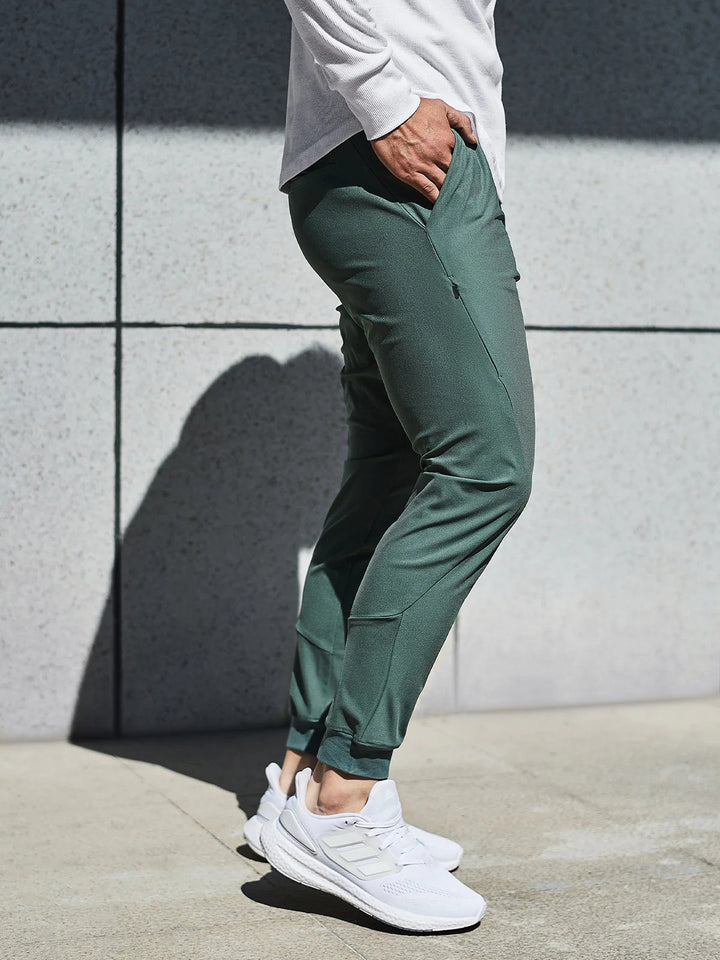 Man running in men's performance joggers, emphasizing movement, activewear & versatile bottoms.