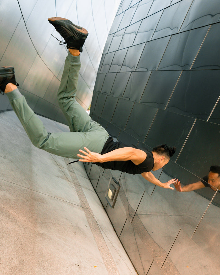 Man stretching in men's stretch pants, performance joggers for flexibility & activewear.