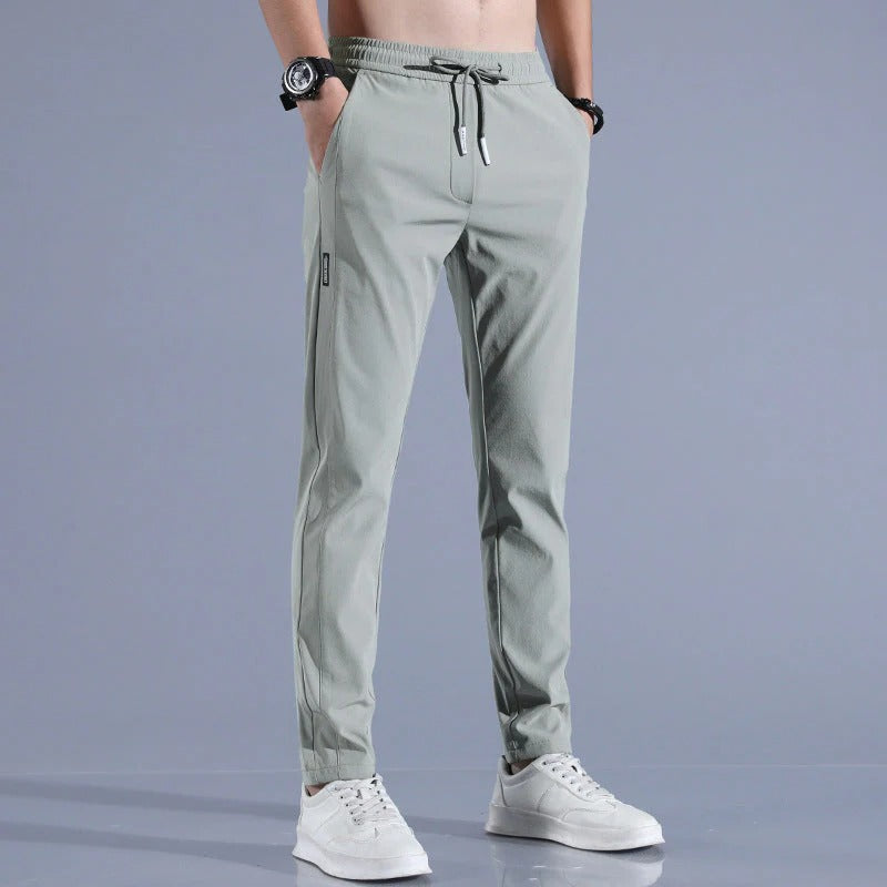 Golfer swinging in versatile men's long golf pants, showing comfortable movement and modern golf attire.