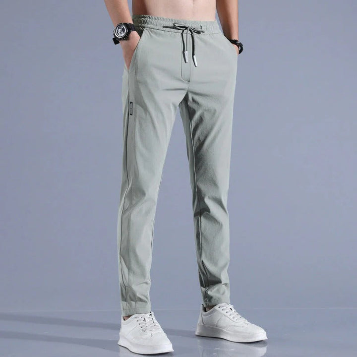 Golfer swinging in versatile men's long golf pants, showing comfortable movement and modern golf attire.