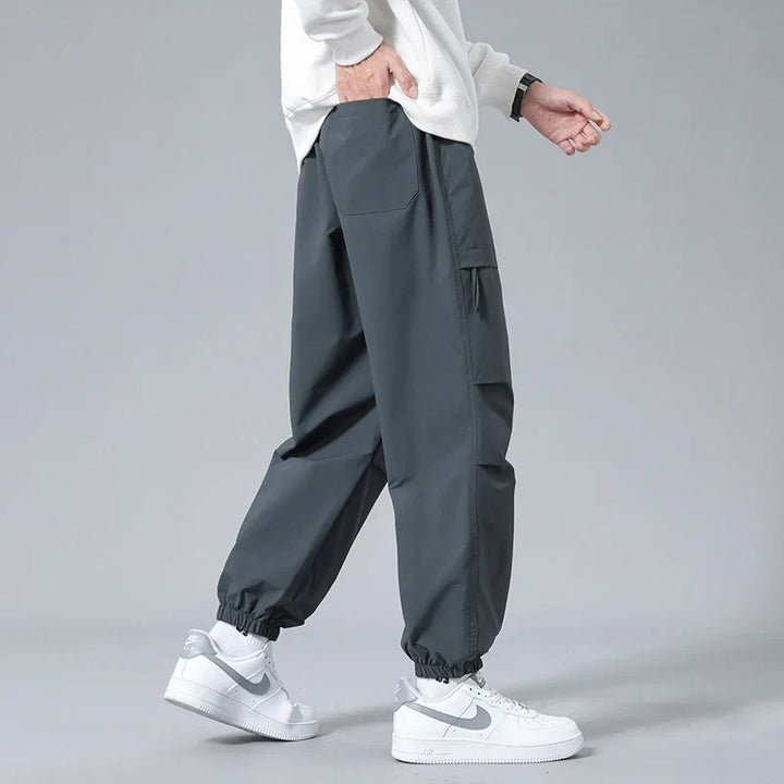 Grey men's utility joggers featuring a comfortable drawstring waist & secure zippered pockets for daily wear.