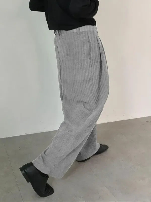 Men's elegant pleated tailored dress trousers. Crafted from a wool blend with a wide leg for sophisticated formal wear.