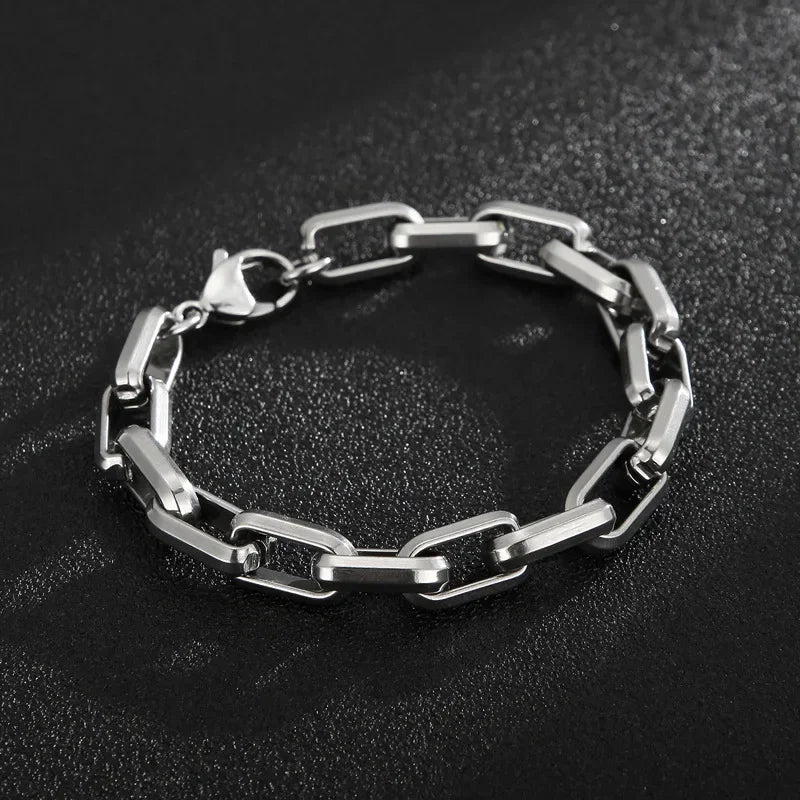 Close-up of a men's stainless steel chain bracelet, showcasing its polished finish & sleek design. Modern men's jewelry.