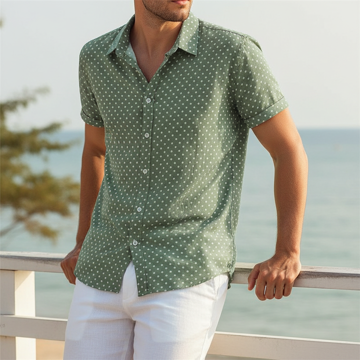 Button-up men's short-sleeve cabana shirt featuring a playful polka dot pattern. Ideal for summer fashion.