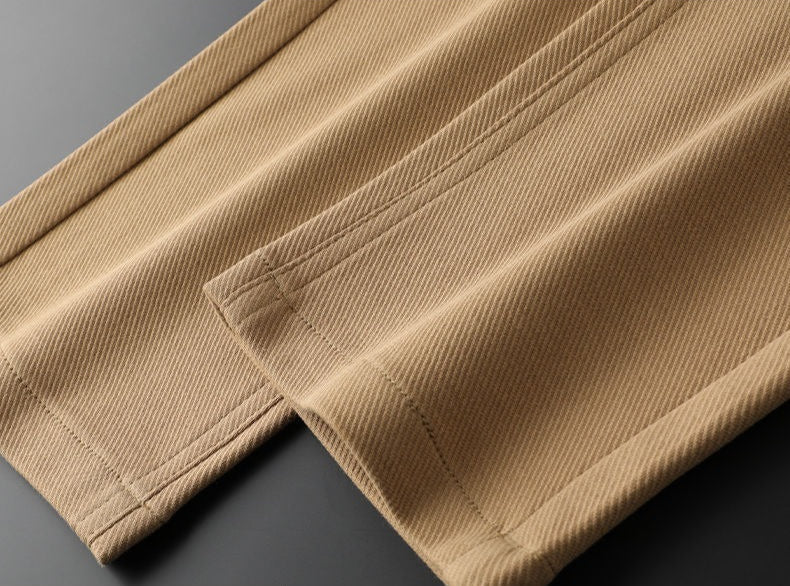 Stack of men's cotton trousers: brown, black, white, khaki. Essential everyday pants for men's fashion.