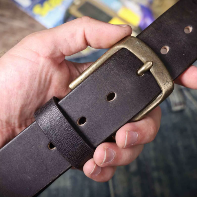 Essential men's fashion accessory: a sleek brown cowhide leather belt with a polished buckle, offering timeless style.