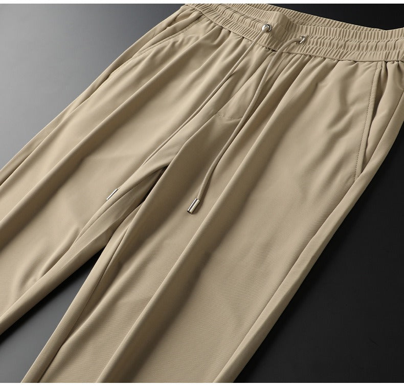 Detail of men's tailored dress trousers waistline, showing button & belt loops for tailored fit.