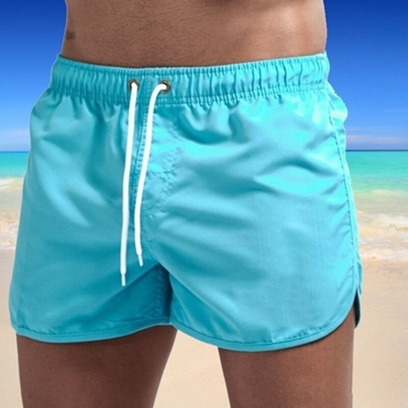 Model wearing blue men's quick-dry swim shorts with a comfort waistband, suitable for summer fashion.