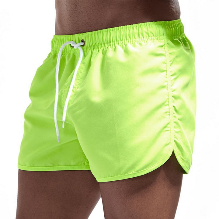 Flat lay of men's athletic quick-dry swim shorts, highlighting the quick-dry fabric and elastic waistband.