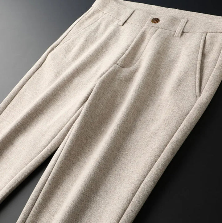 Flat lay of Regent tailored men's dress pants, emphasizing sharp pleats and a refined, tailored design.