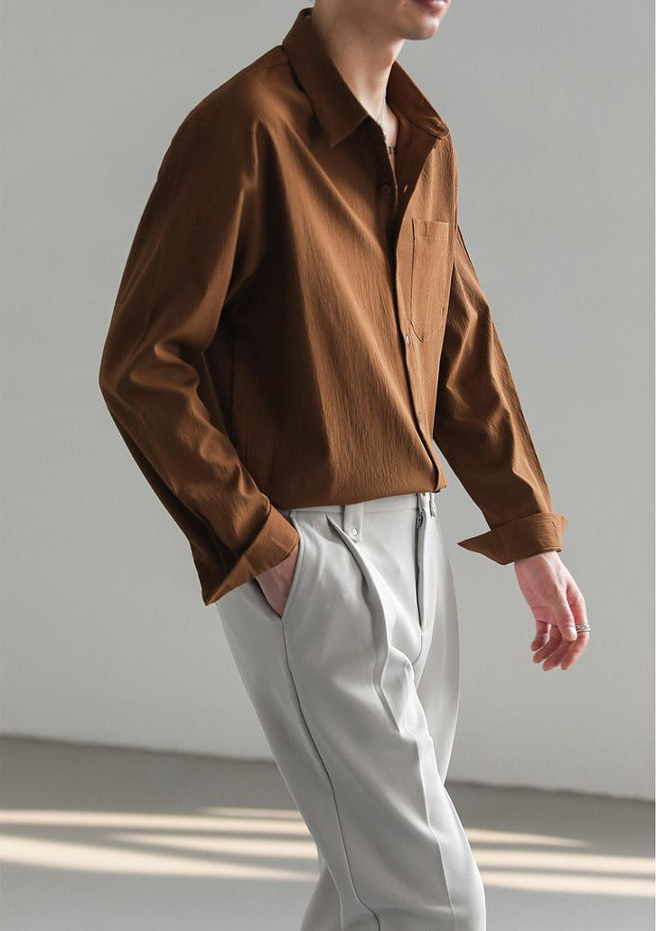 Neatly folded men's relaxed fit long-sleeve button-up shirt, ready for versatile, comfortable everyday wear.