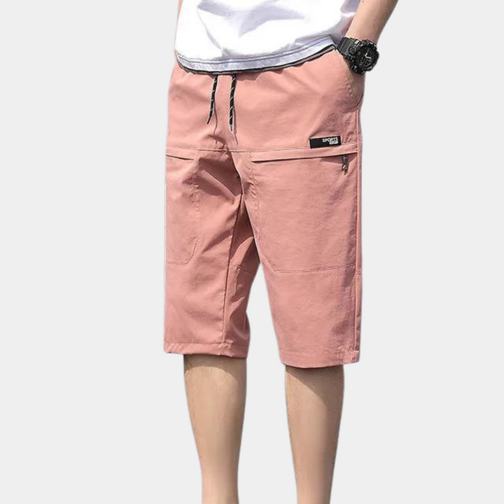 Model wearing casual men's cargo shorts with a relaxed fit, showcasing summer fashion.