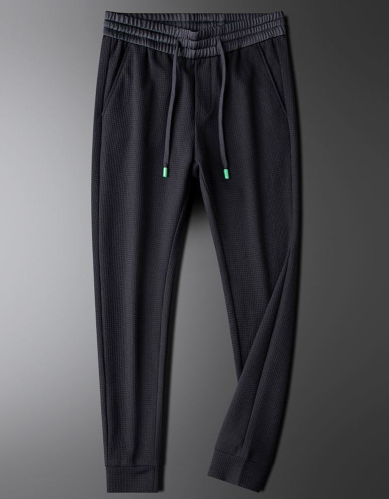Detail shot of men's relaxed fit casual pants, highlighting comfortable fabric and modern cut.