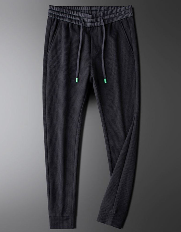 Detail shot of men's relaxed fit casual pants, highlighting comfortable fabric and modern cut.