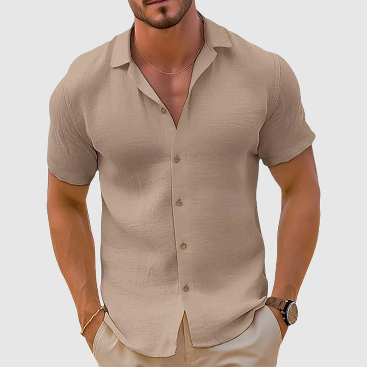 Man wearing a light blue relaxed fit collared shirt, perfect for everyday summer fashion. Breathable short sleeve top.