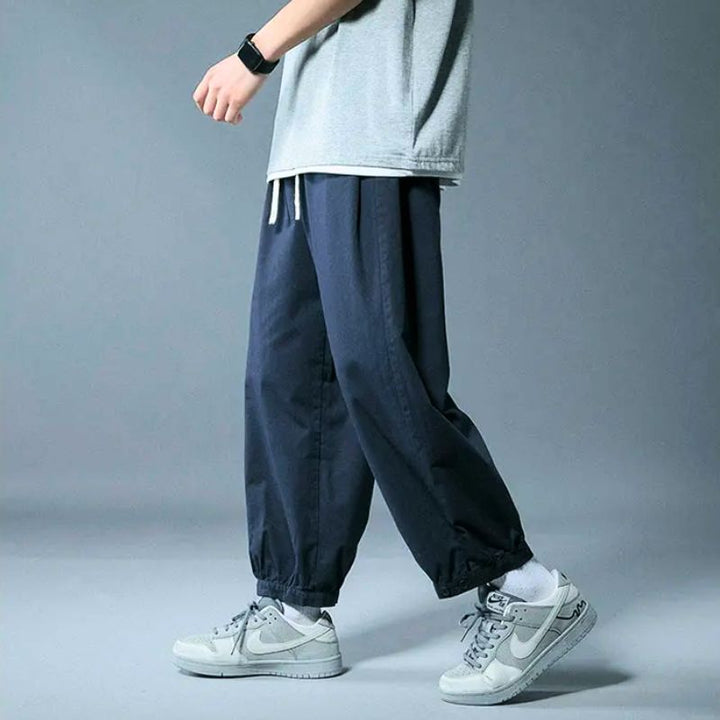 Stylish men's relaxed fit pants with a comfy drawstring waist and elastic cuffs, ideal for casual and everyday wear.