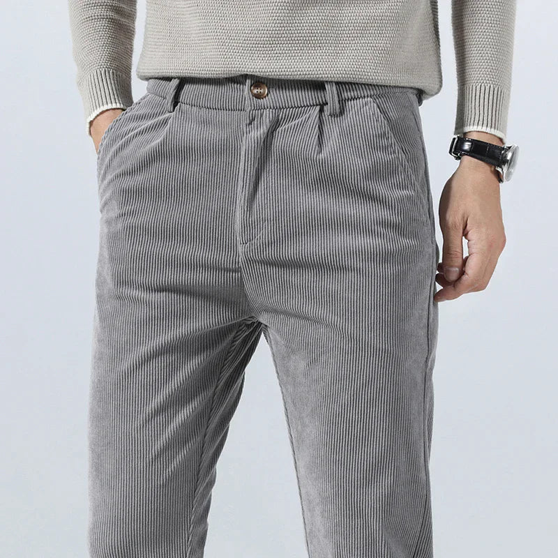 Close-up of the textured fabric on men's relaxed fit beige corduroy trousers.