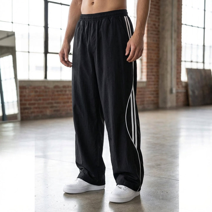 Men's relaxed fit joggers in black with white side stripes, perfect for casual wear or active lifestyles.