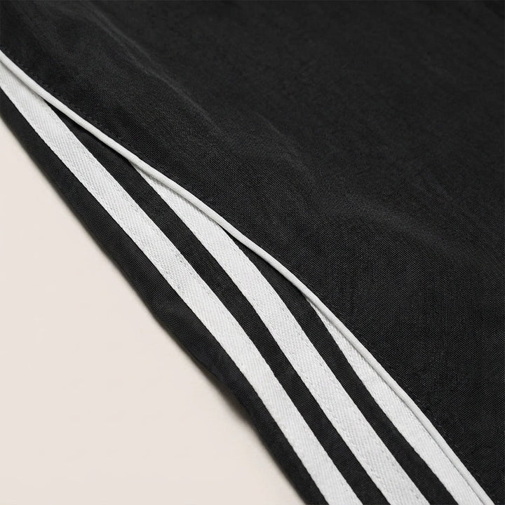 Sporty men's track pants, relaxed fit, featuring stylish side stripes, ideal for activewear or casual outings.