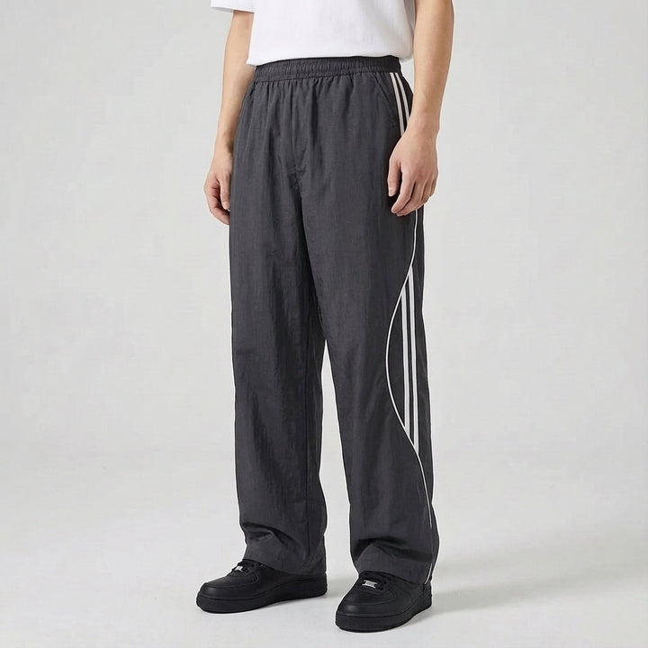 Trendy men's loungewear joggers, dark blue with an athletic side stripe design, combining comfort and style.
