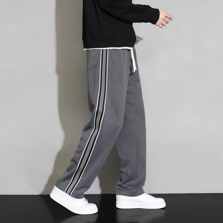 Sporty men's relaxed fit joggers. Features an athletic side stripe, drawstring & soft polyester for activewear & lounging.