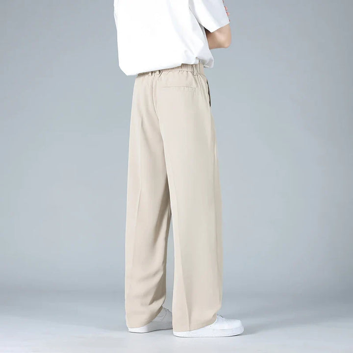 Black men's relaxed fit pleated dress trousers, a modern essential for formal wear & smart casual looks.