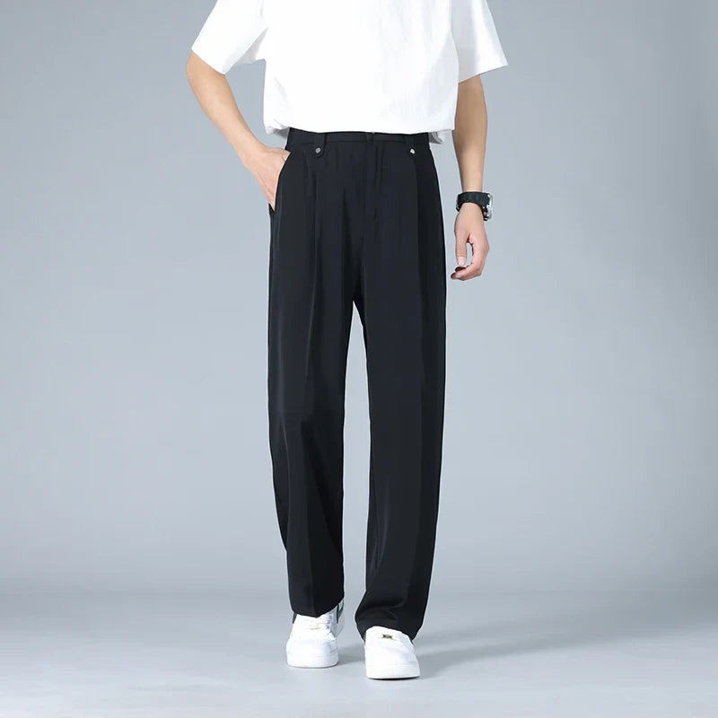 Grey men's relaxed fit pleated dress trousers, offering comfort and versatile modern style for work & events.