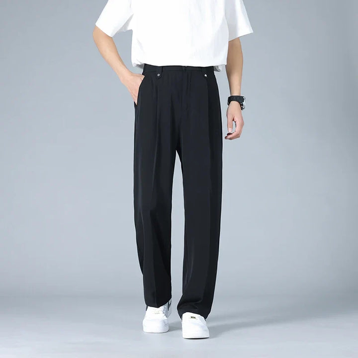 Grey men's relaxed fit pleated dress trousers, offering comfort and versatile modern style for work & events.