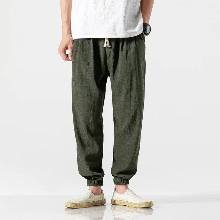 Man styling relaxed fit tapered joggers with sneakers, showcasing modern, comfortable everyday look.