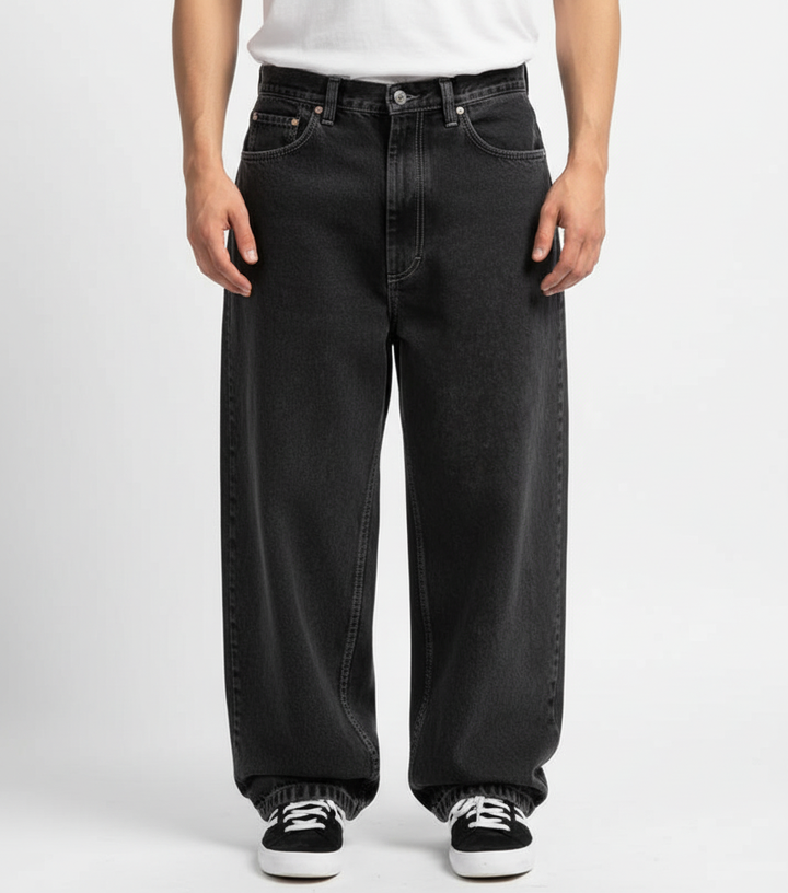 Close-up of knee area on relaxed fit jeans, showing denim texture and urban style.