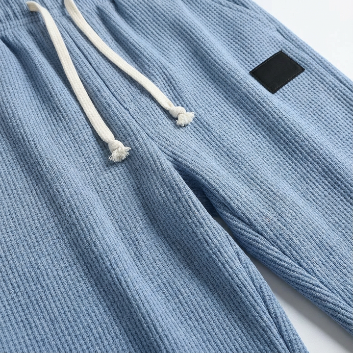 Soft men's waffle knit pants, relaxed fit with drawstring, perfect for lounging.