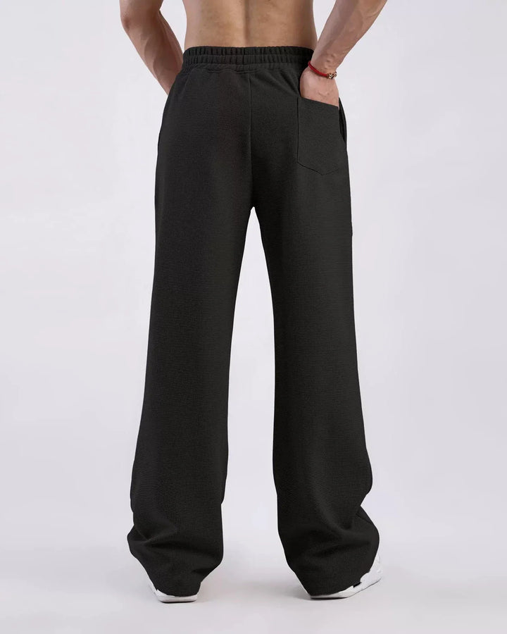 Man wearing relaxed fit waffle sweatpants, demonstrating comfortable, casual style; perfect for spring/summer.