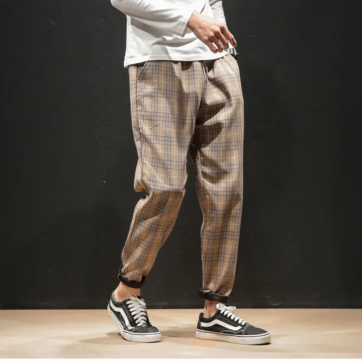 Modern men's plaid trousers with a sleek tapered leg, perfect for contemporary style and comfort.