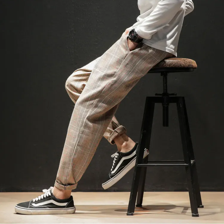Men's plaid trousers styled casually with sneakers, demonstrating modern comfort and relaxed fit.