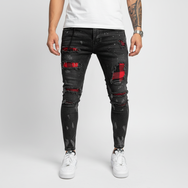 Close-up of torn knee on men's slim fit jeans, showcasing ripped denim & stylish patches.